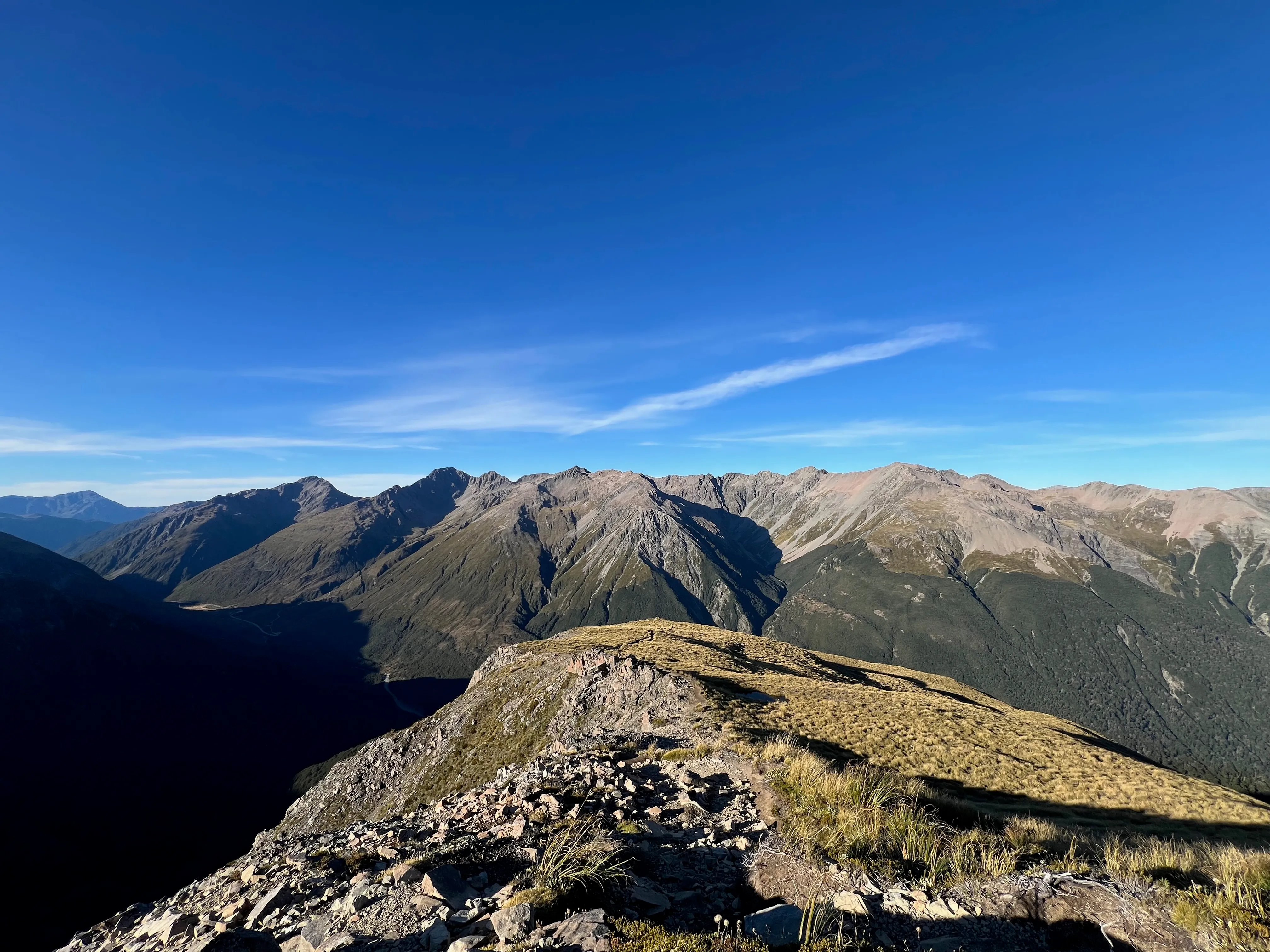 A rocky ridge looking out over layered mountain ranges.