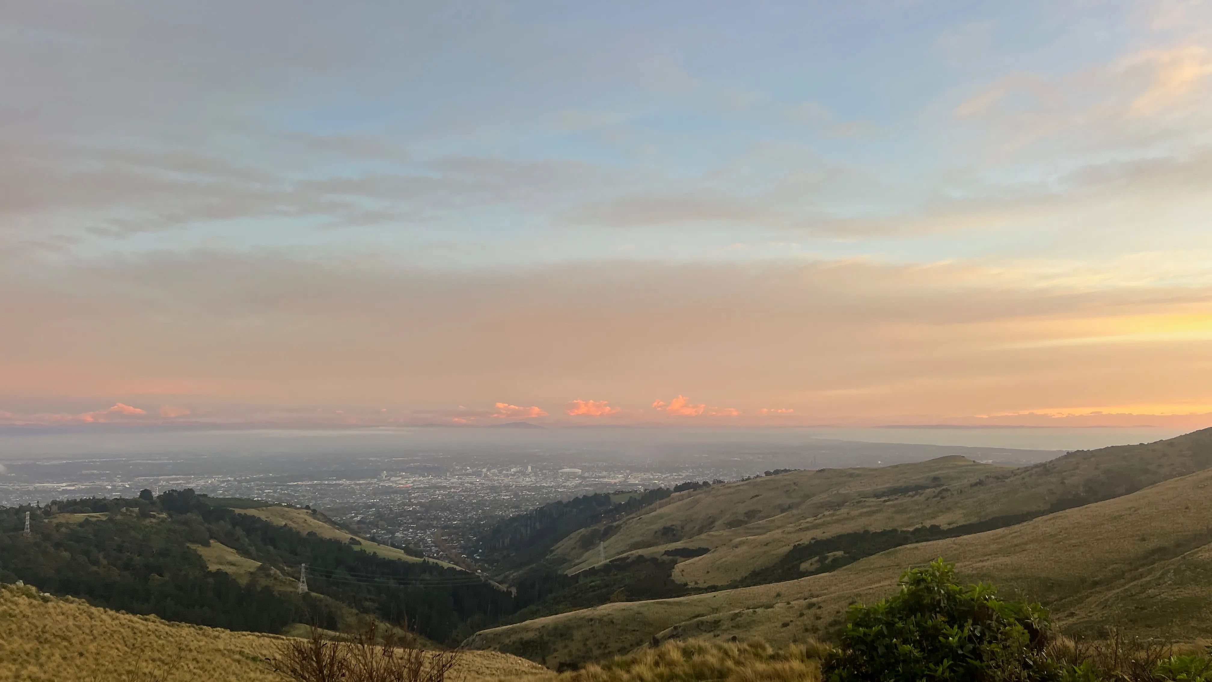 Christchurch spread across the plains below the tussock hills at dawn.