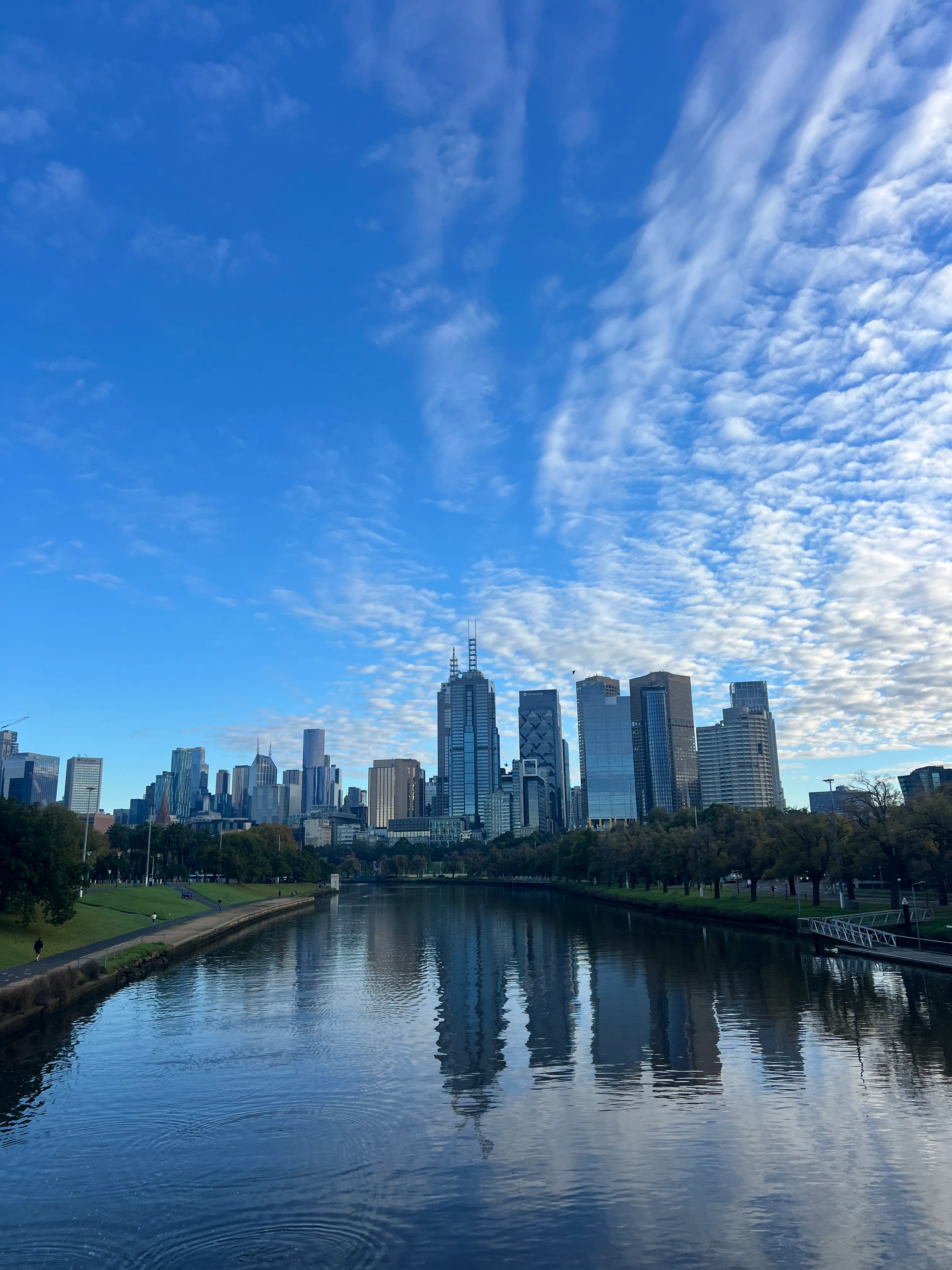 The Melbourne skyline mirrored in the Yarra in morning light.