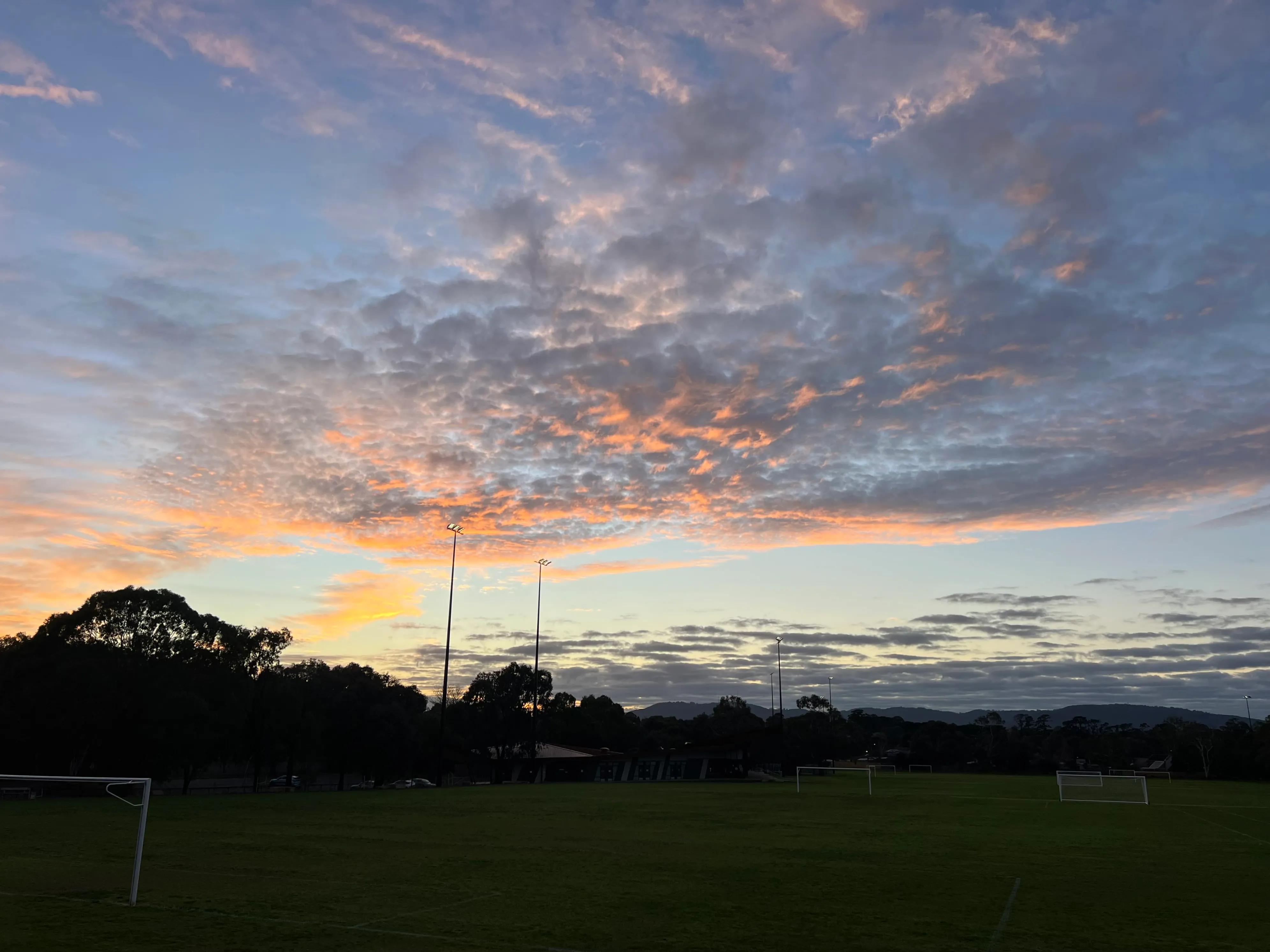 Sunrise glowing over a sports field.