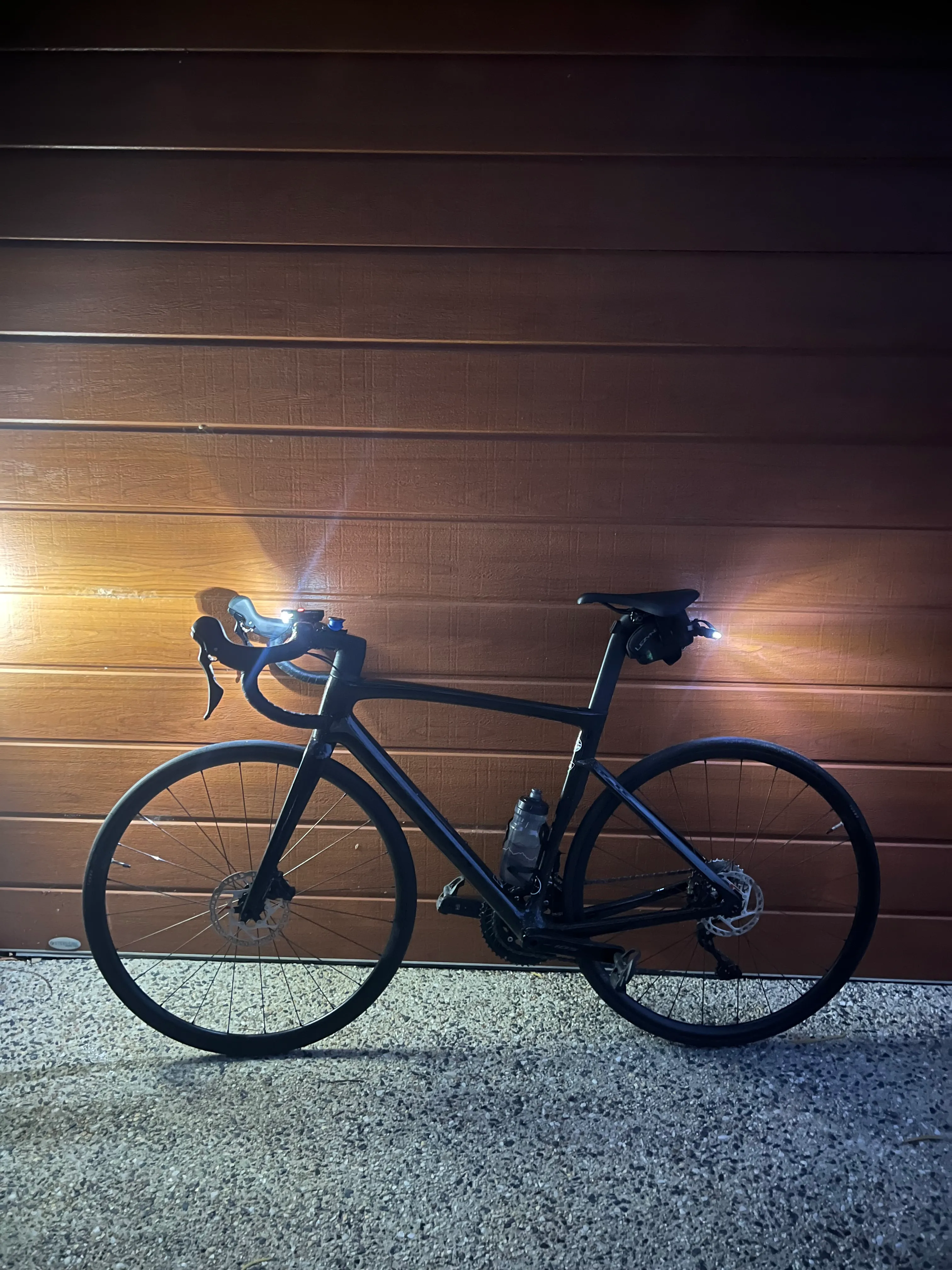 A bike against a timber wall at night.