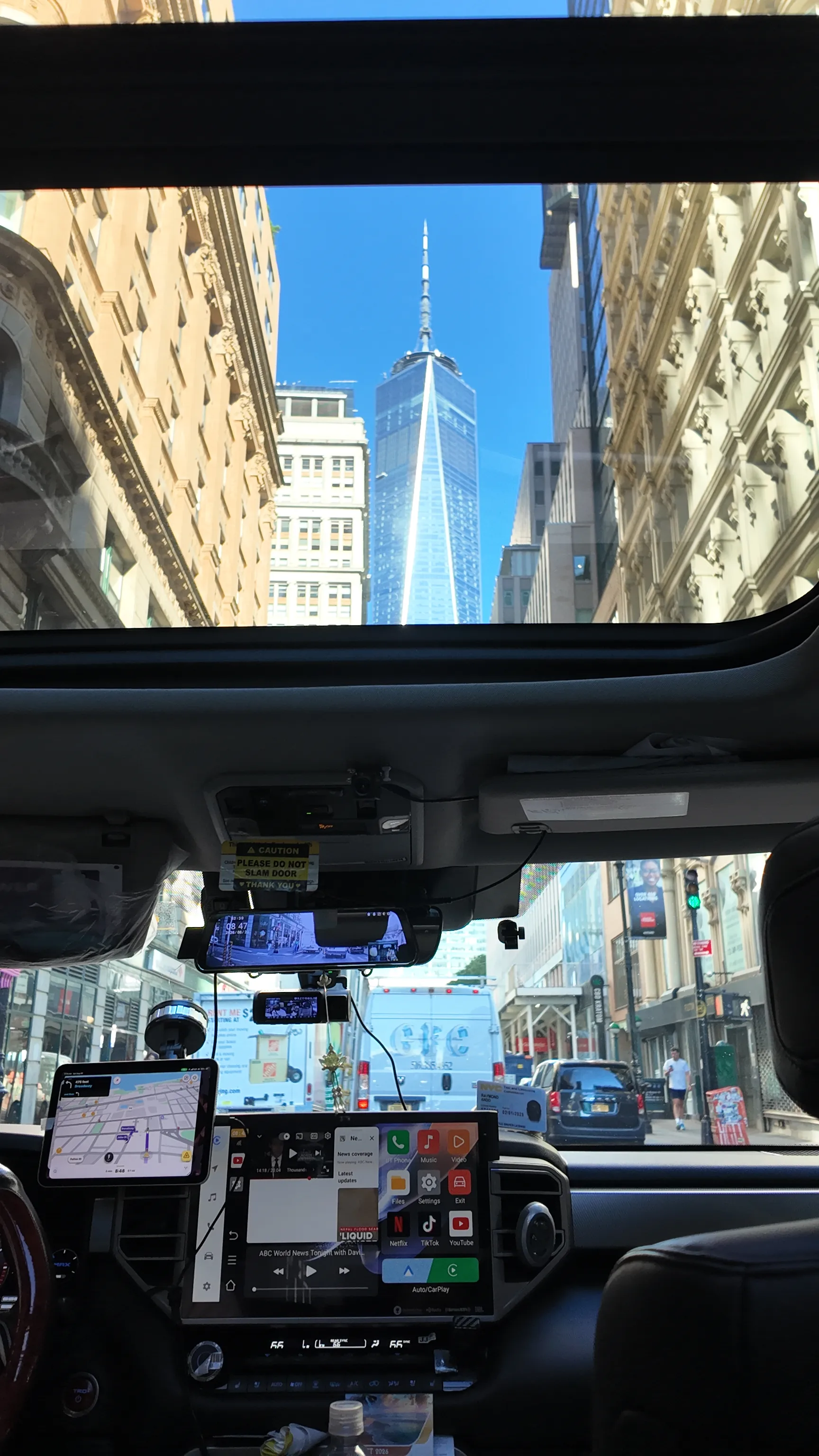 A skyscraper seen through the windows of a city bus.