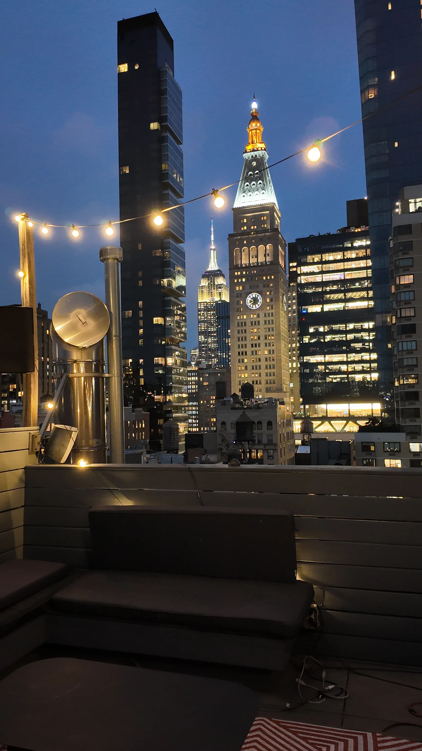 Illuminated towers and terrace lights against the evening sky.