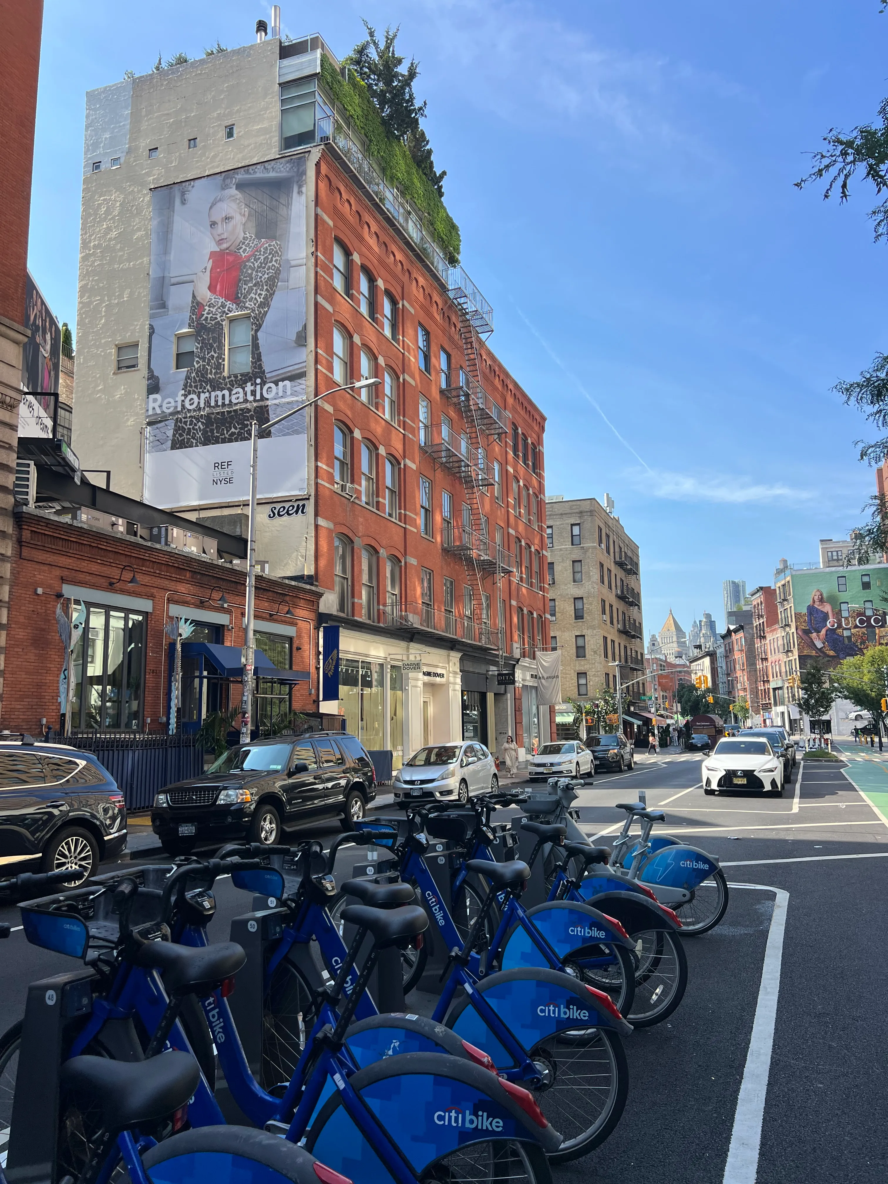 A brick corner building beside a row of parked blue bicycles.