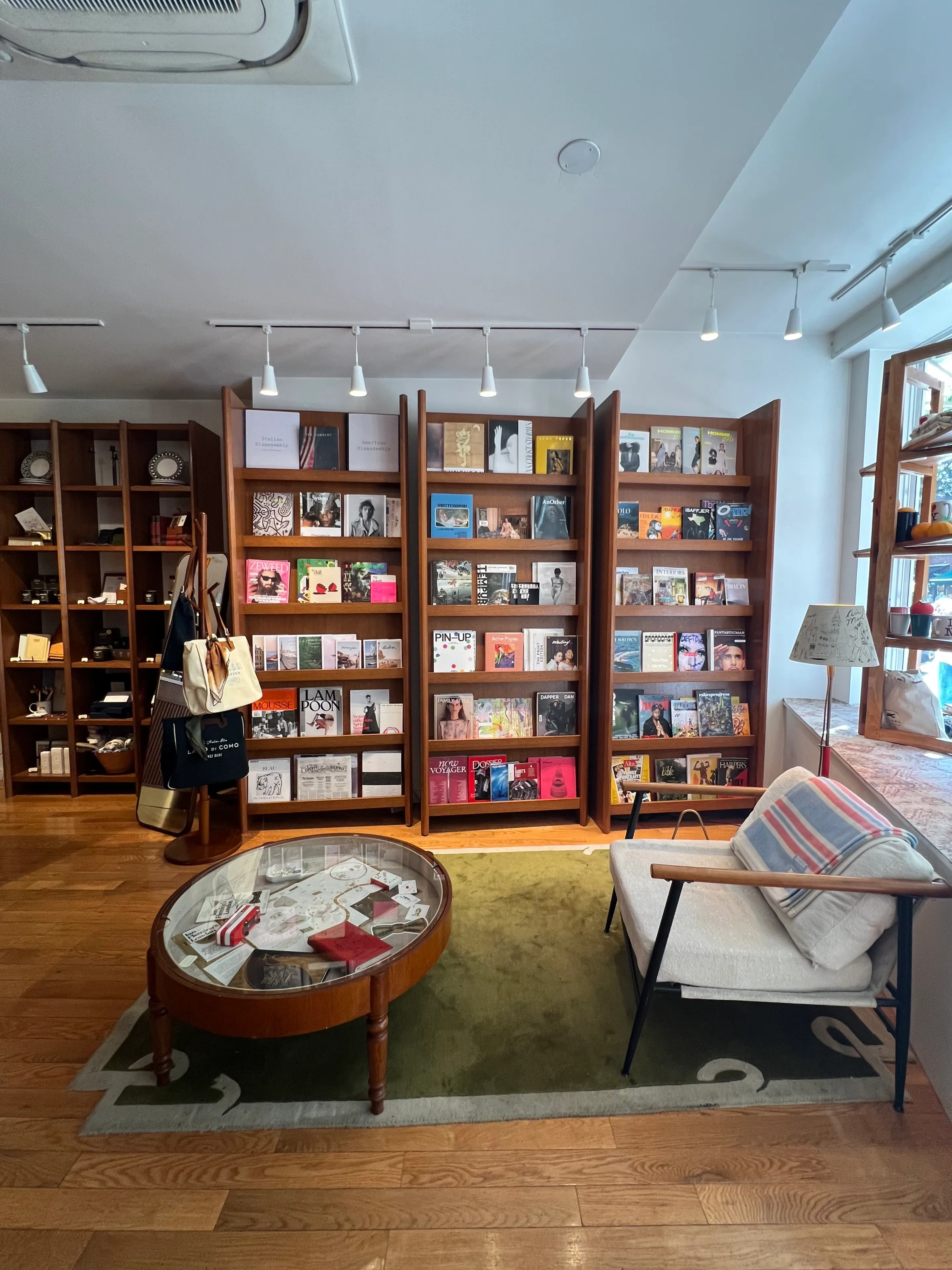 The interior of Air Mail, a stationery and magazine store, with wall-to-wall shelves of titles and a mid-century sitting area.