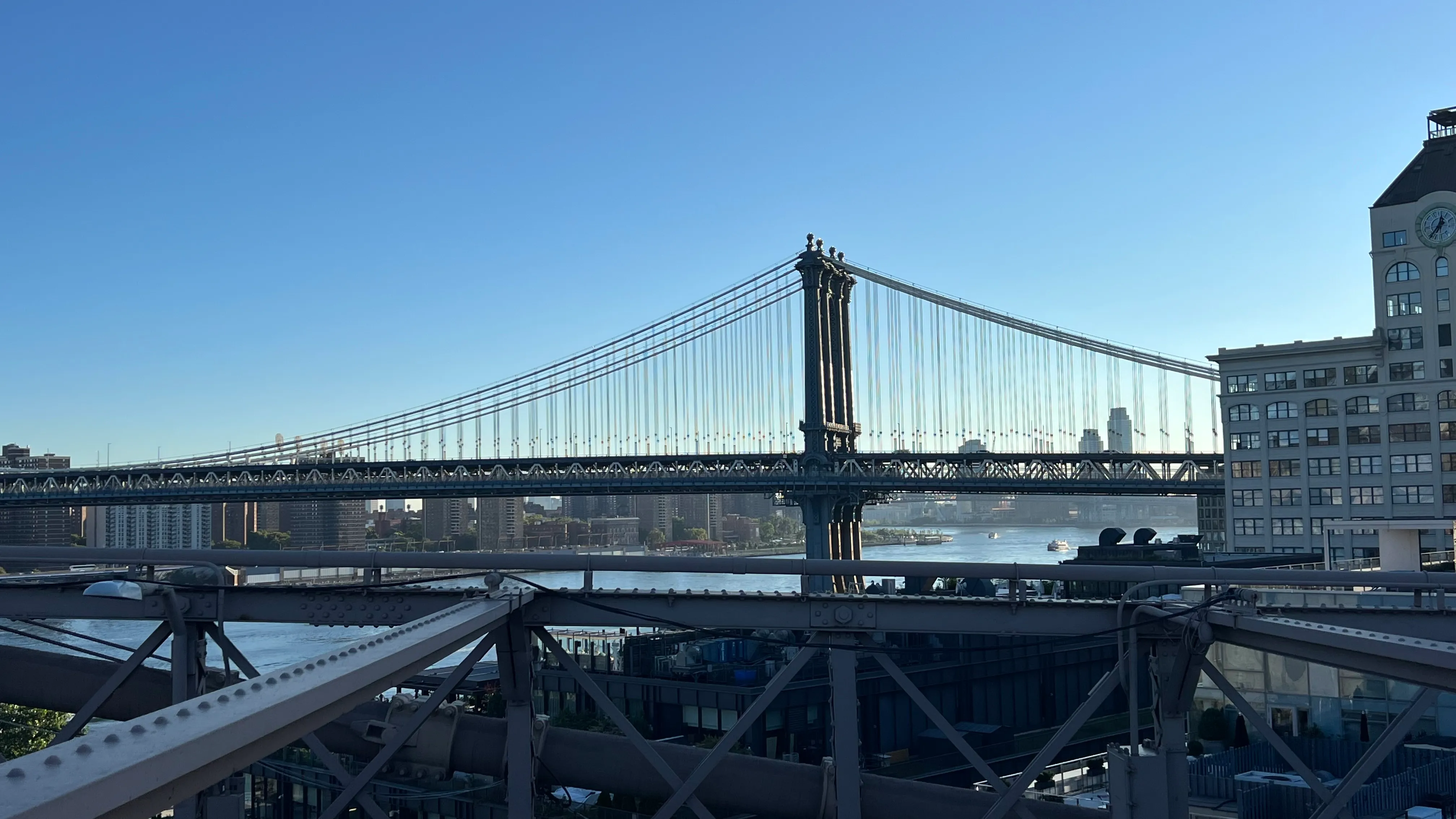 The Manhattan Bridge's towers and cables seen from a Brooklyn rooftop across the East River.